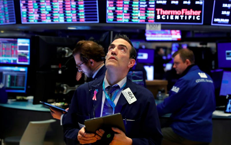 A man at the NYSE looks up at the ticker tape.