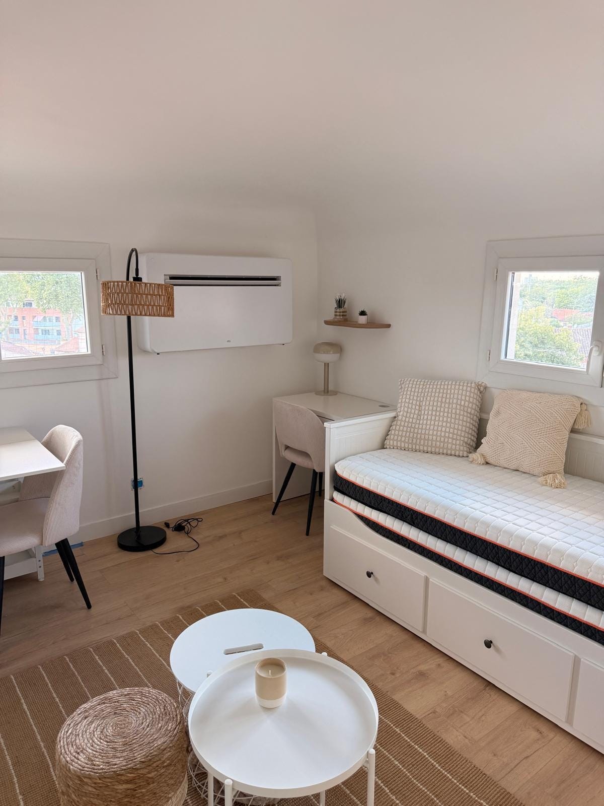 Le séjour lumineux du studio rénové, avec banquette, coin bureau et climatisation Le séjour lumineux du studio rénové, avec banquette, coin bureau et climatisation