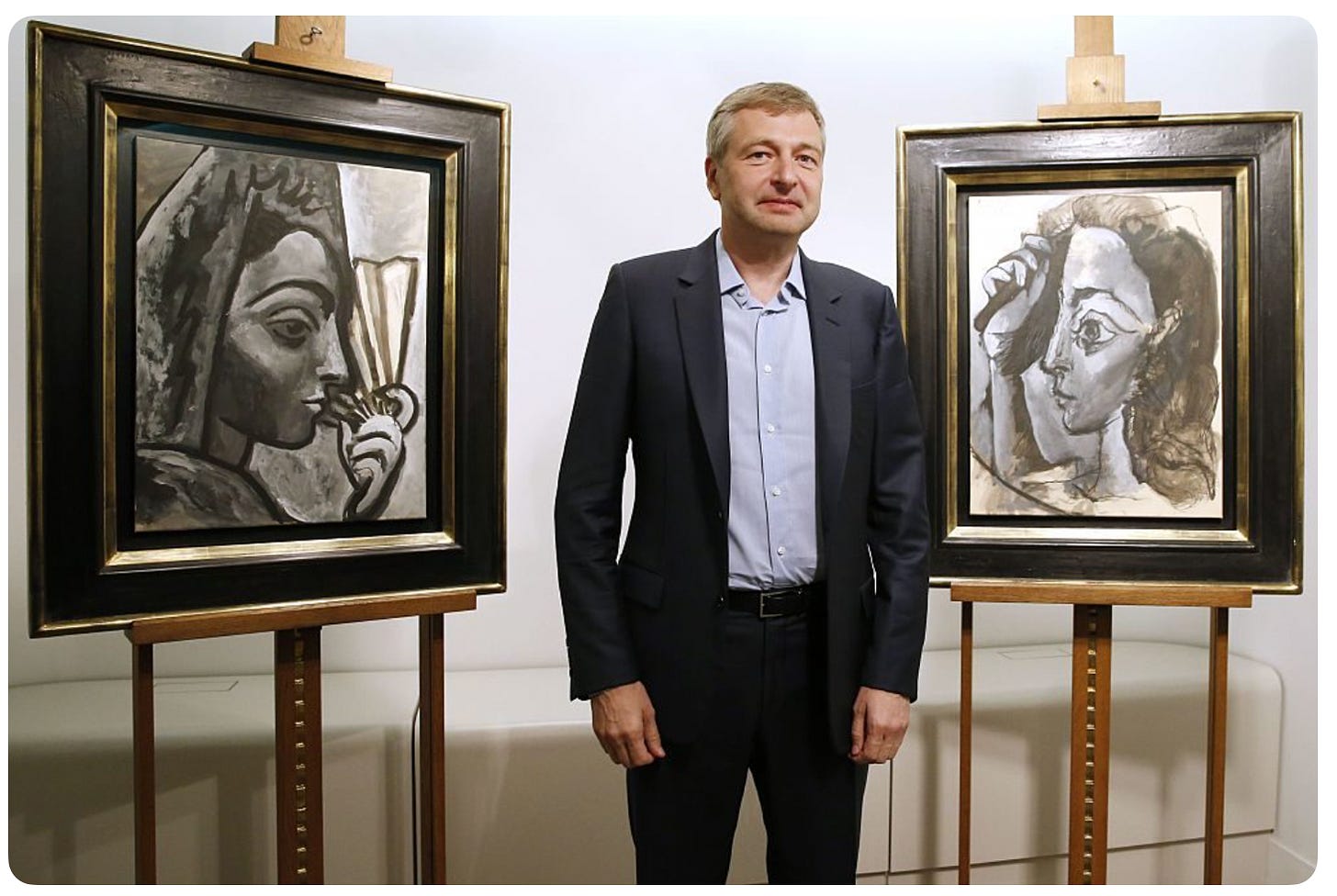 Dmitry Rubolovlev in front of two Pablo Picasso paintings, Espagnole a l’Eventail and Femmes se Coiffant. Image: Patrick Kovarik/AFP/Getty images. Dmitry Rubolovlev in front of two Pablo Picasso paintings, Espagnole a l’Eventail and Femmes se Coiffant. Image: Patrick Kovarik/AFP/Getty images.