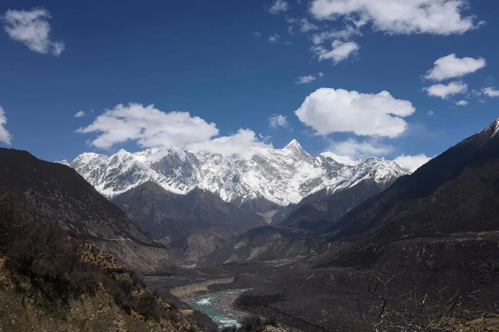 A dramatic, mountainous landscape with a river in the foreground. A dramatic, mountainous landscape with a river in the foreground.