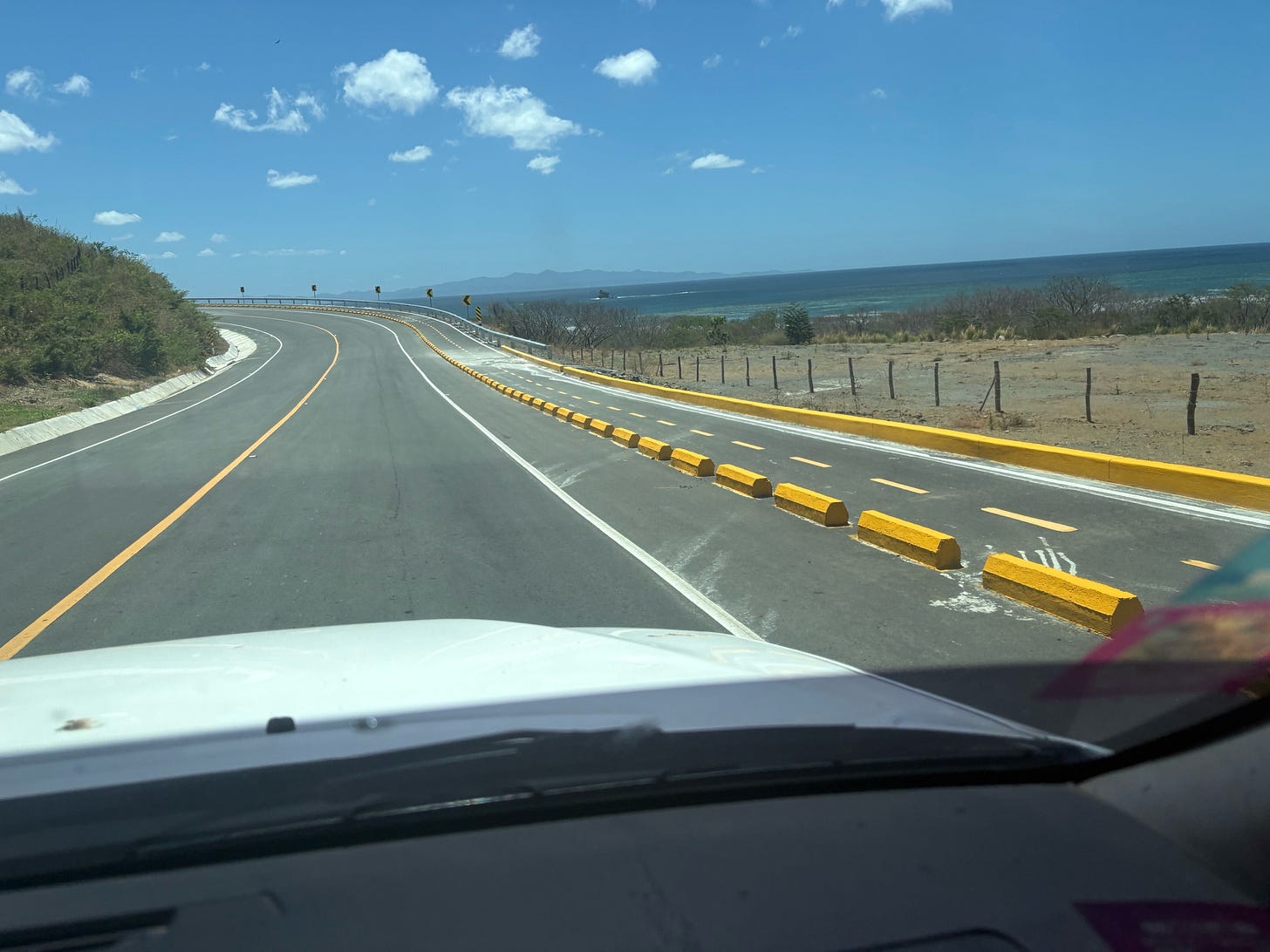 A road with yellow curbs and blue sky
AI-generated content may be incorrect.