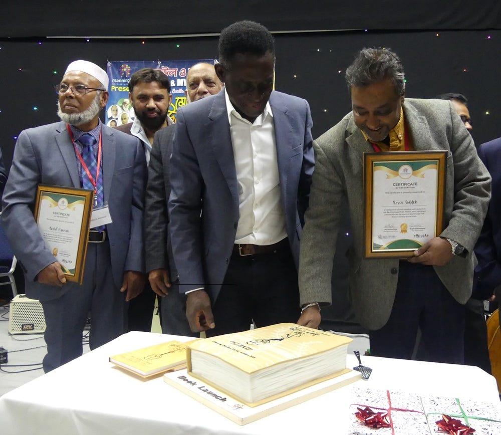 anningham Housing's vice chair, Rupert Pometsey (centre left) and writer Novin Siddek inspect the specially commissioned cake at the launch of Baul & Mystic Songs of South Asian Heritage Volumes 1 & 2 anningham Housing's vice chair, Rupert Pometsey (centre left) and writer Novin Siddek inspect the specially commissioned cake at the launch of Baul & Mystic Songs of South Asian Heritage Volumes 1 & 2