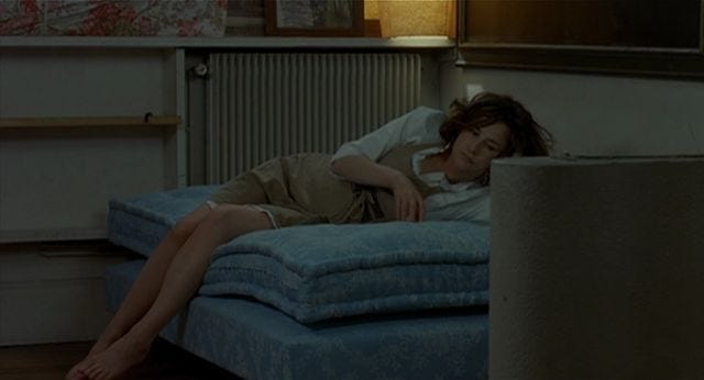 Woman lies on her side on a bare mattress Woman lies on her side on a bare mattress