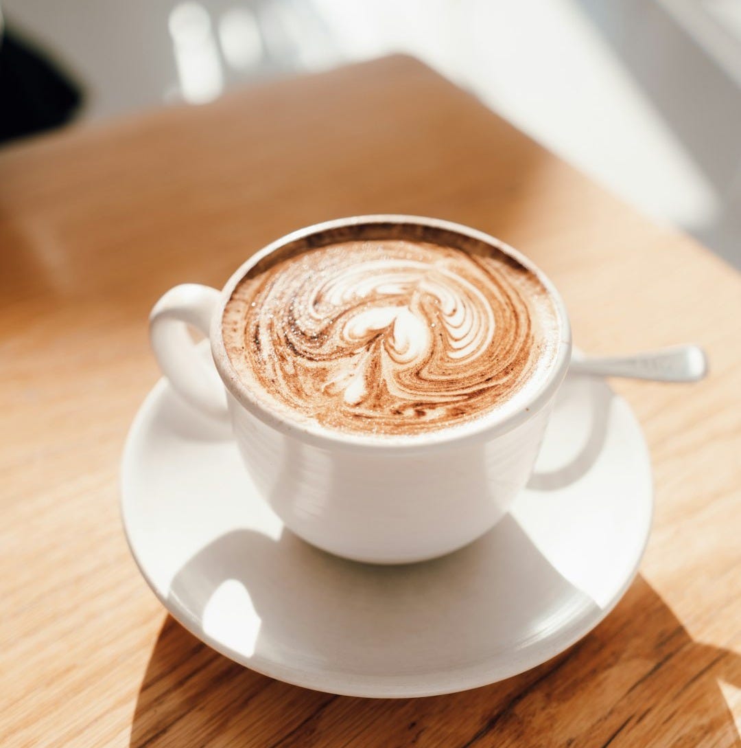 white ceramic cup with saucer on brown wooden table