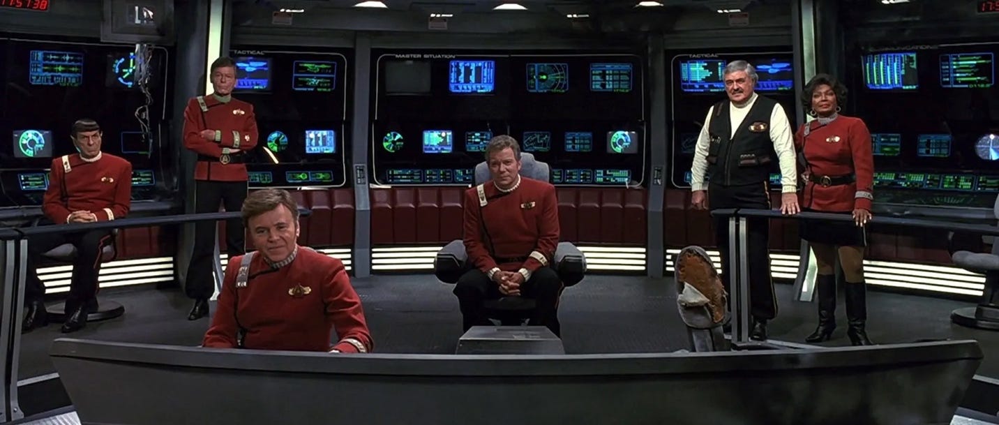 A group of men in red uniforms sitting in chairs

Description automatically generated