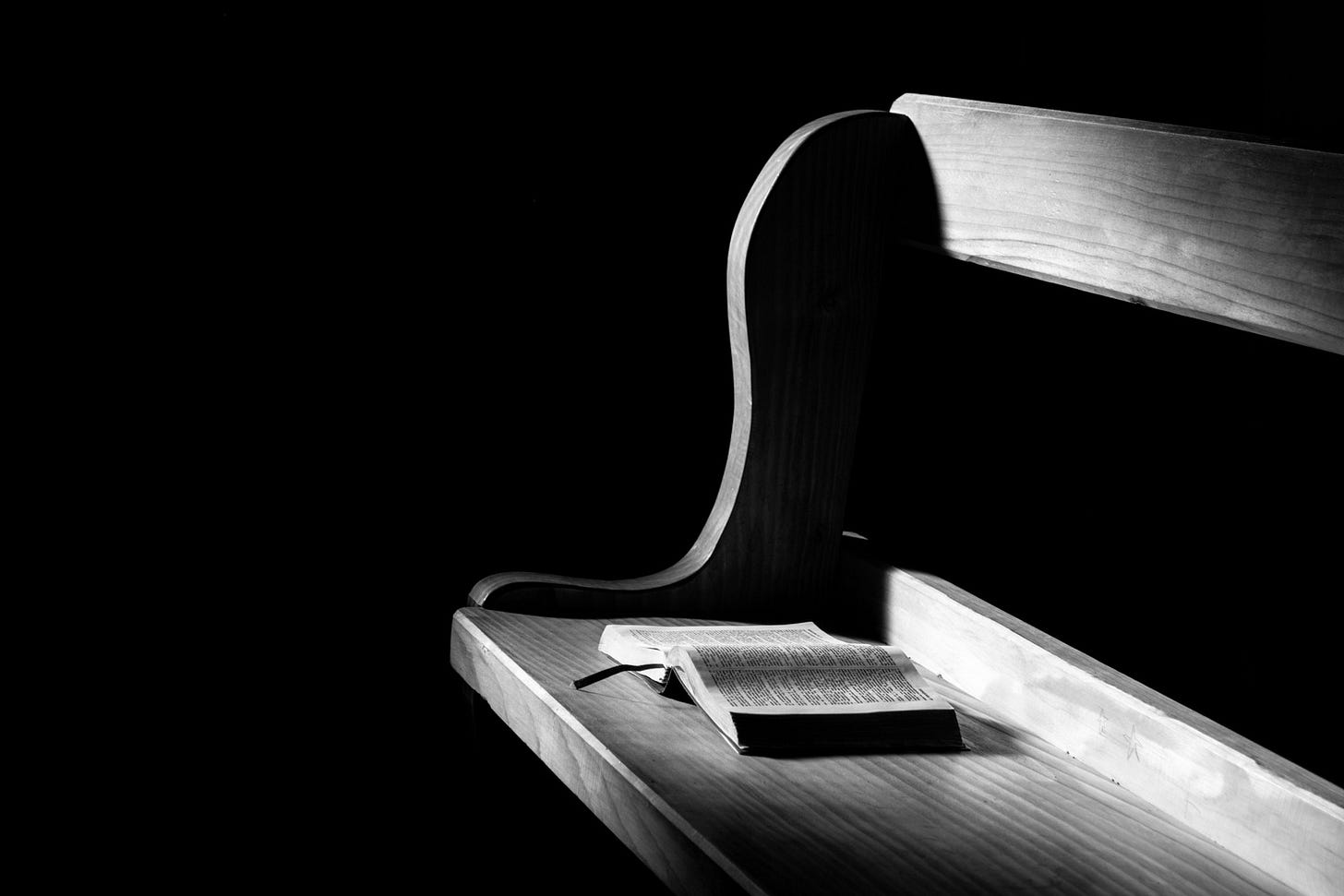 a church pew with a bible open
