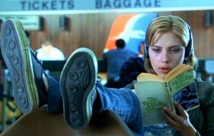 This may contain: a woman with headphones is reading a book