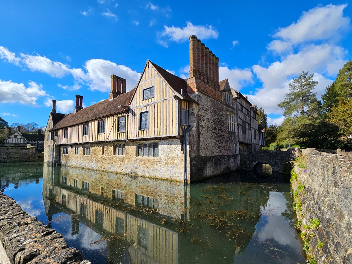 A tudor-style house surrounded by a moat