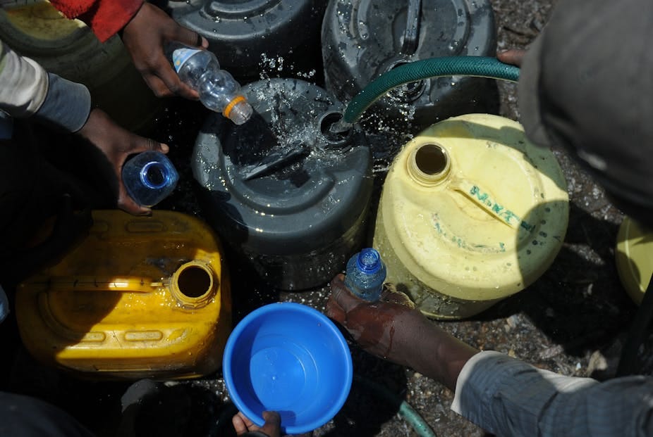 Residents fetch water in small bottles Residents fetch water in small bottles