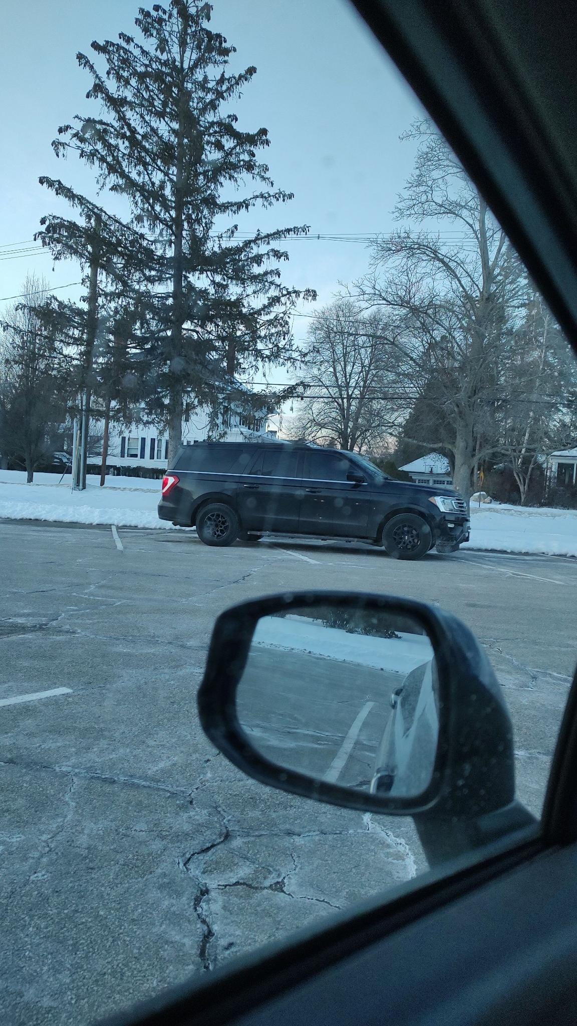 A black SUV idles in a chilly church parking lot,
