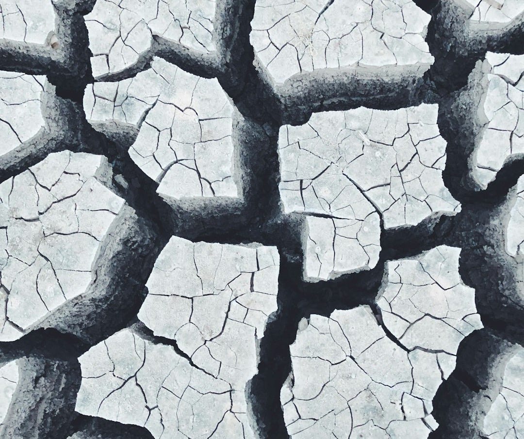 a person standing in the middle of a cracked road a person standing in the middle of a cracked road