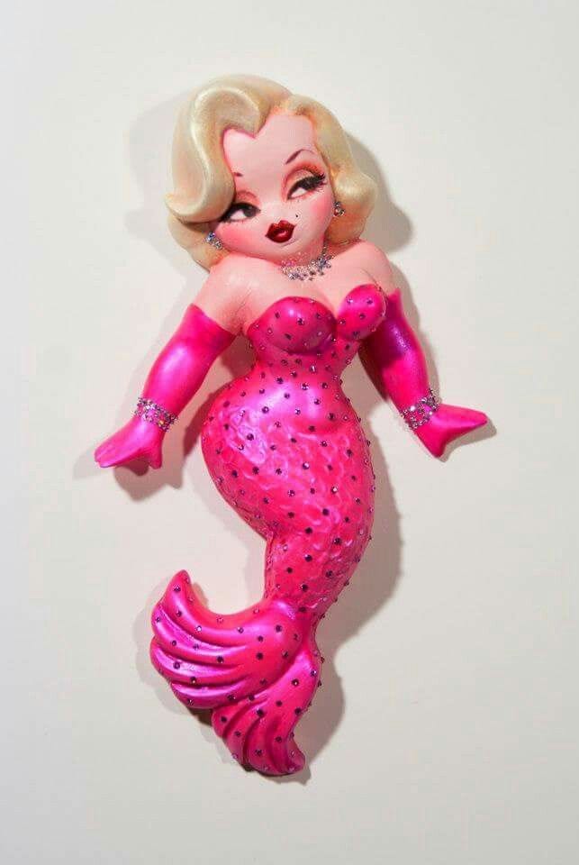 This may contain: there is a pink plastic figurine that looks like a mermaid