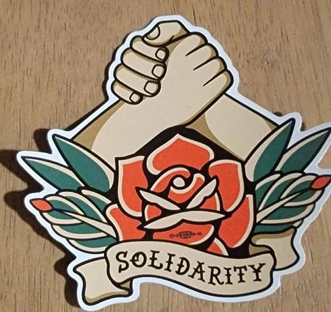 Pride flag that says "Proud Union Queer";' hands shaking over a rose in vintage tattoo style with the word "Solidarity" on a scroll; star that says "best union sibling"