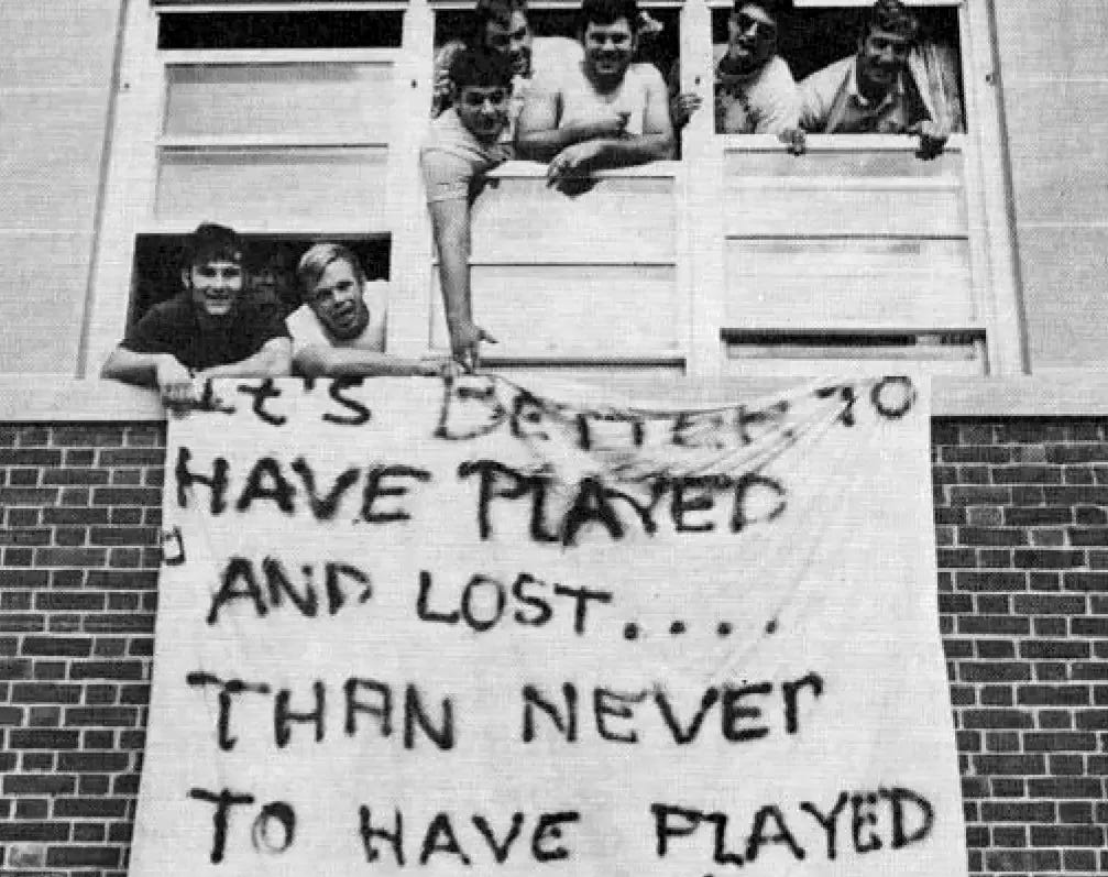 A group of quarantined players hang a bedsheet sign: "It's better to have played and lost...than to have never played at all." A group of quarantined players hang a bedsheet sign: "It's better to have played and lost...than to have never played at all."