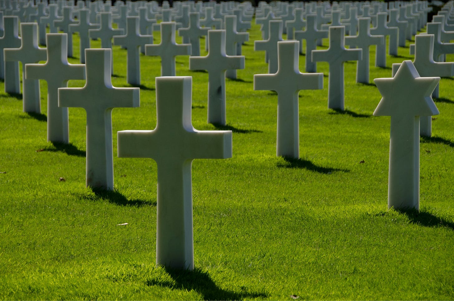 cemetery in green open field during daytime cemetery in green open field during daytime