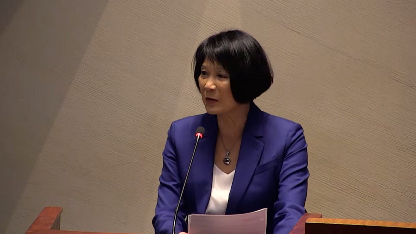 Mayor Olivia Chow wearing a purple jacket while speaking at a lectern