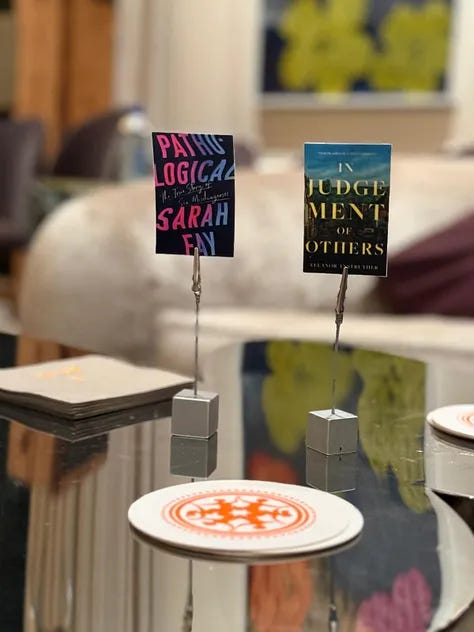 Flowers and a woman behind them, two images of book covers, cookies with the image of Pathological on them