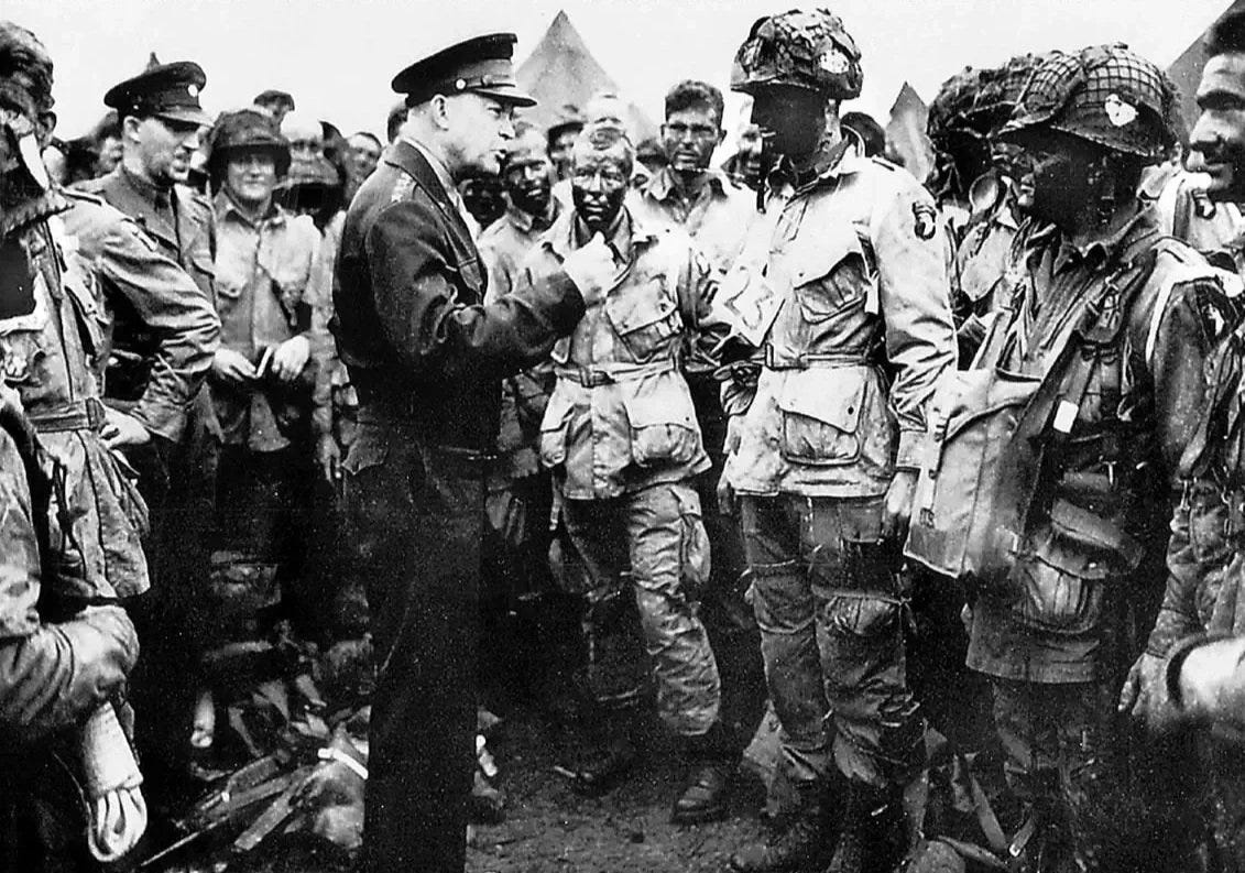 Black and white photograph of President Eisenhower speaking to an assembled group of 101st Airborne soldiers before the D-Day invasion.