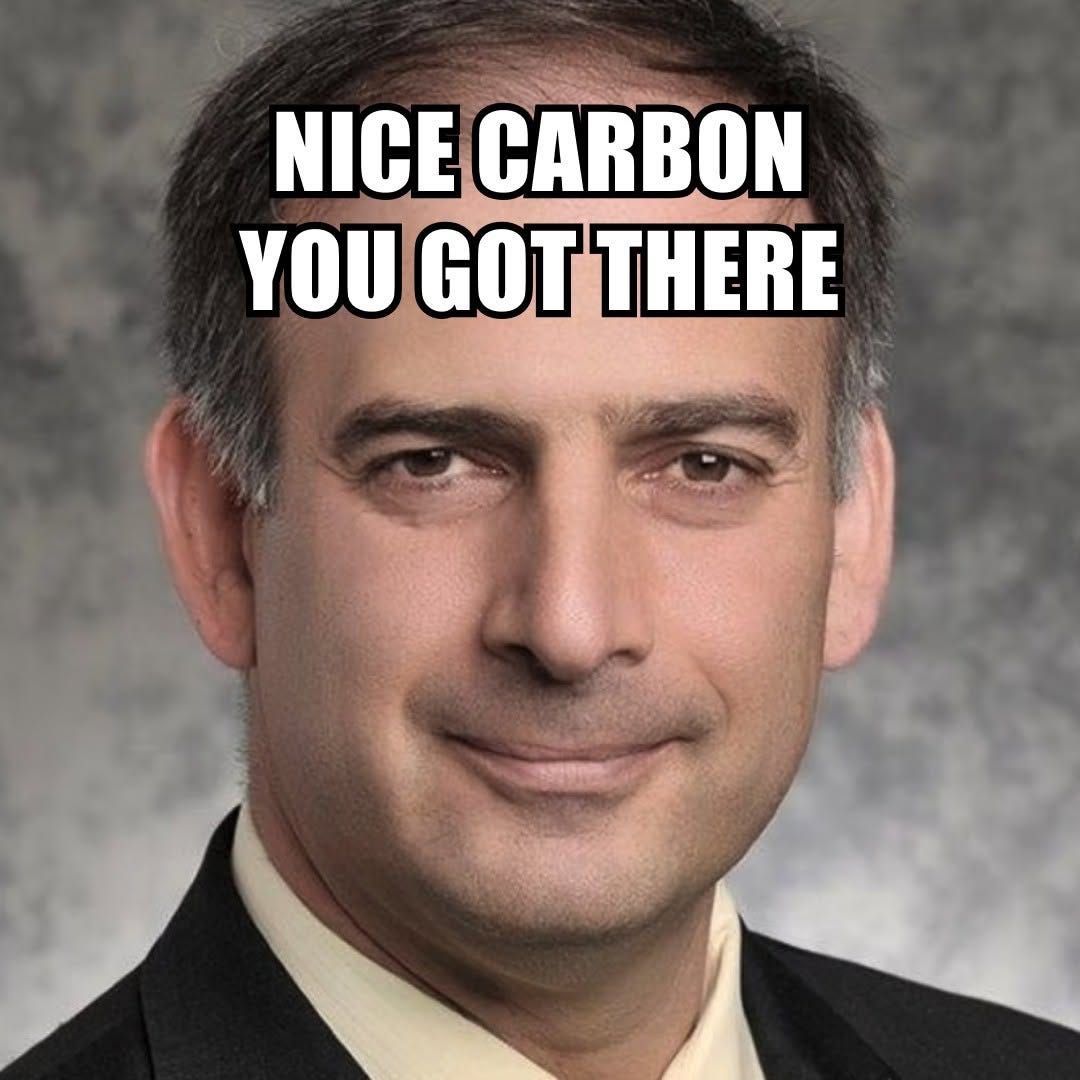 Close-up of a smiling man in a suit, captioned "Nice carbon you got there."