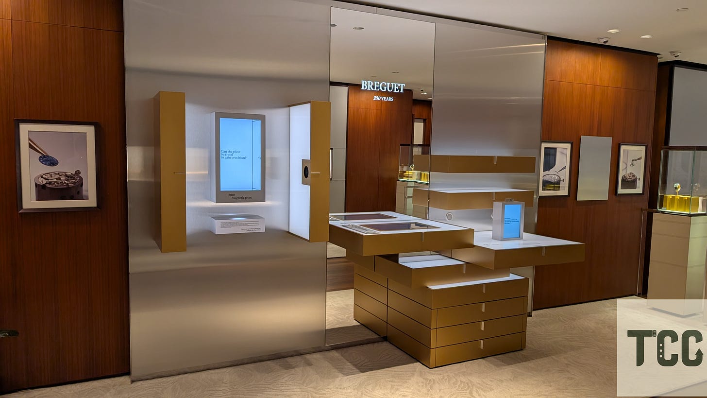 Interactive exhibit area in the Breguet boutique featuring a display about the magnetic pivot, surrounded by framed horological images.