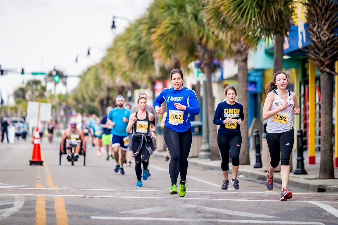 group of people running on the road during daytime group of people running on the road during daytime