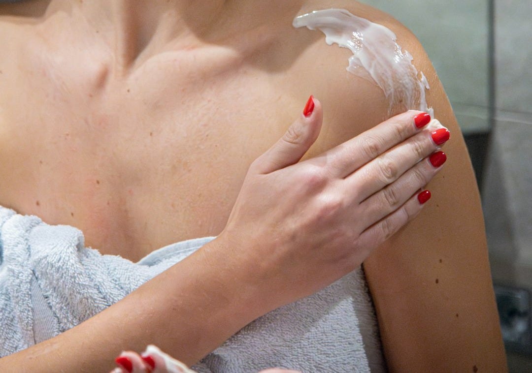 a woman with a towel on her head is shaving her face a woman with a towel on her head is shaving her face
