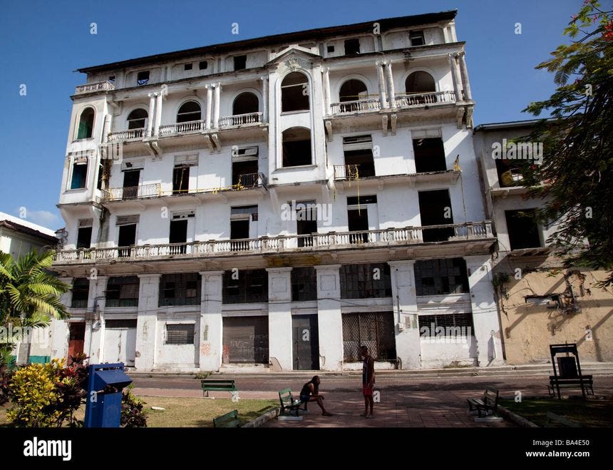 A five story building, in need of restoration, in Herrara Park in Old Panama City. Colonial style balconies, whitewashed - Stock Image