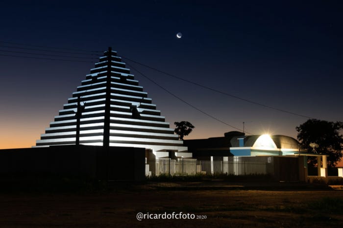 piramide iluminada durante o nascer do sol com a lua ao fundo