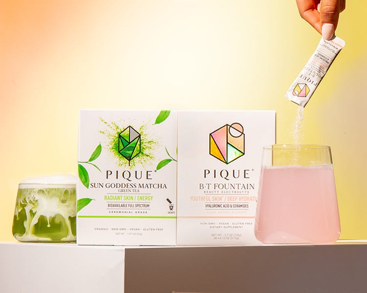 Someone pouring Pique electrolyte powder into a glass of water.
