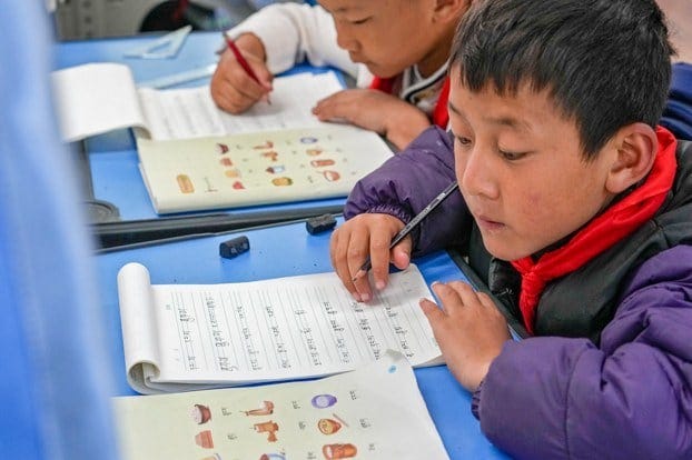2023 年 9 月 5 日，在媒体组织的参观活动中，藏族学生在香格里拉重点寄宿学校一年级课堂上学习藏文。