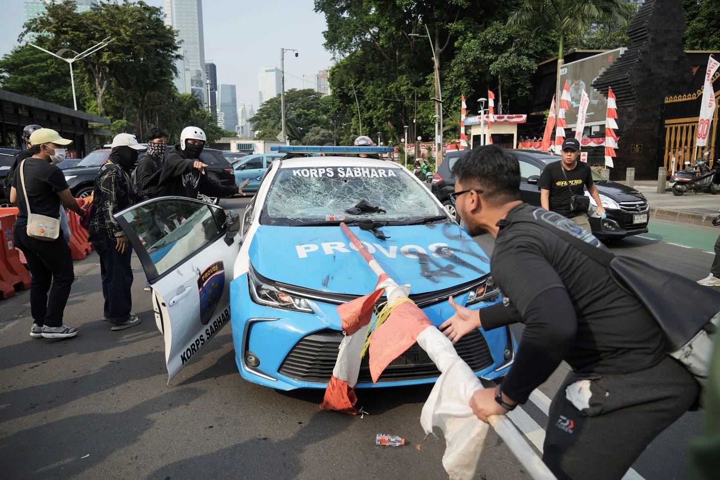 印尼首都雅加达街头爆发激烈示威抗争，民众持棍棒砸毁警车。（美联社）