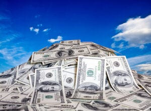 pile of money with blue sky in background