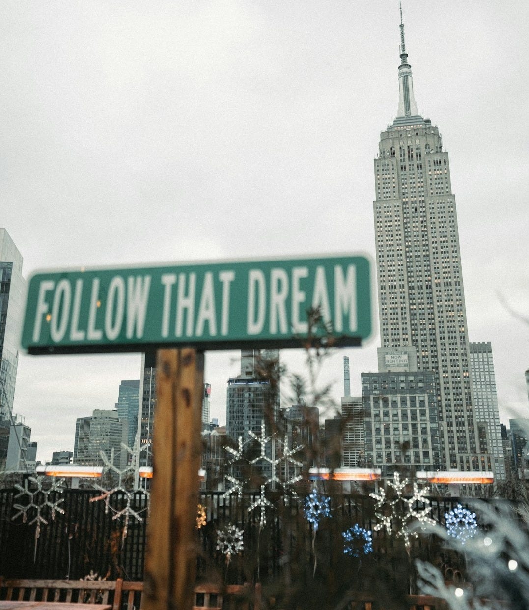 a street sign that reads follow that dream