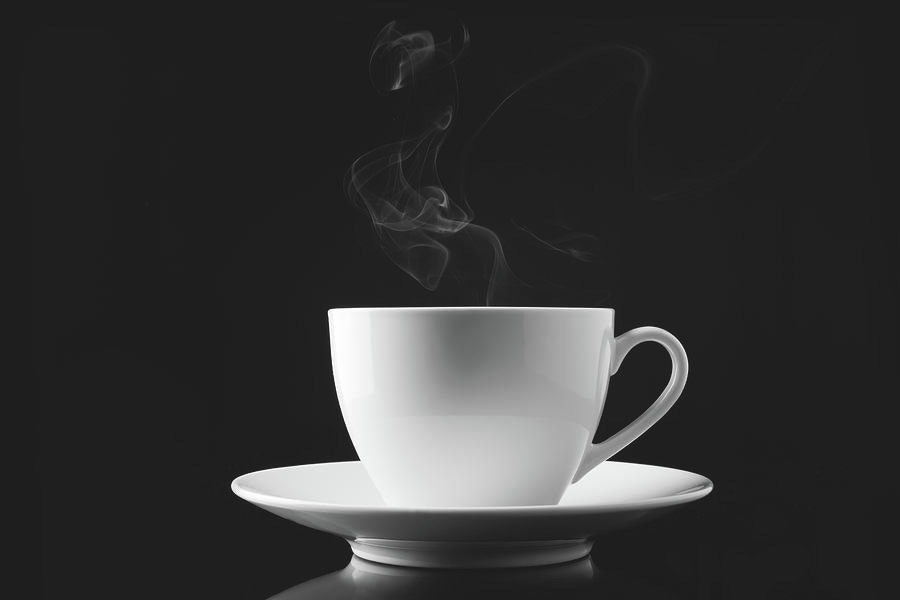 A Cup Of Smoking Hot Coffee On A Black by V2images A Cup Of Smoking Hot Coffee On A Black by V2images