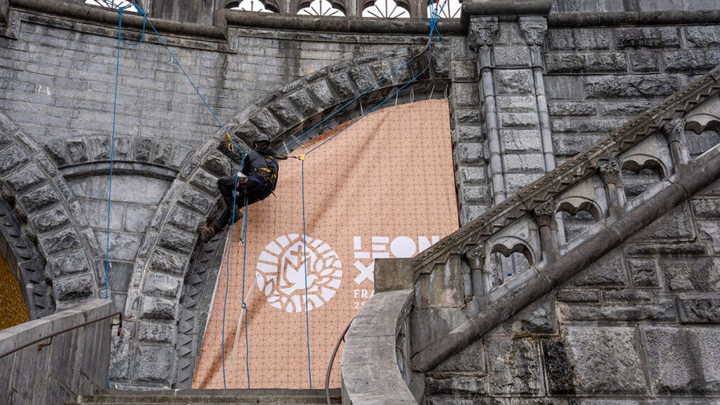 Worker covering Rupnik mosaics at Lourdes Worker covering Rupnik mosaics at Lourdes