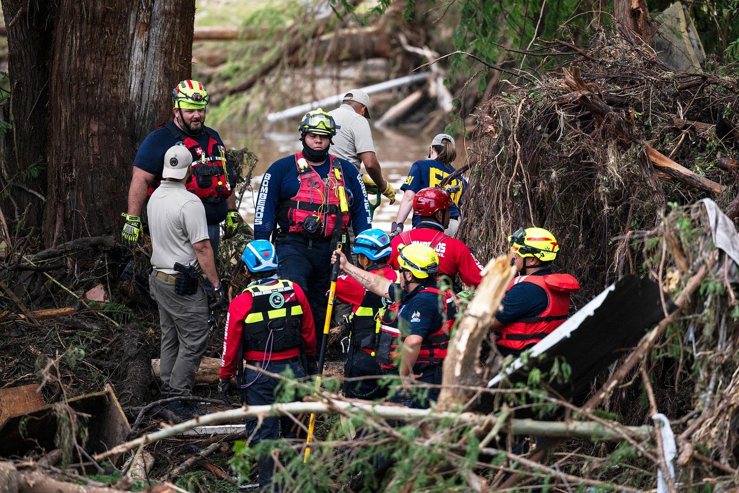 Firefighters from Ciudad Acuna, Mexico, aid in search and rescue efforts Monday near the Guadalupe River days after a flash flood swept through the area in Ingram, Texas