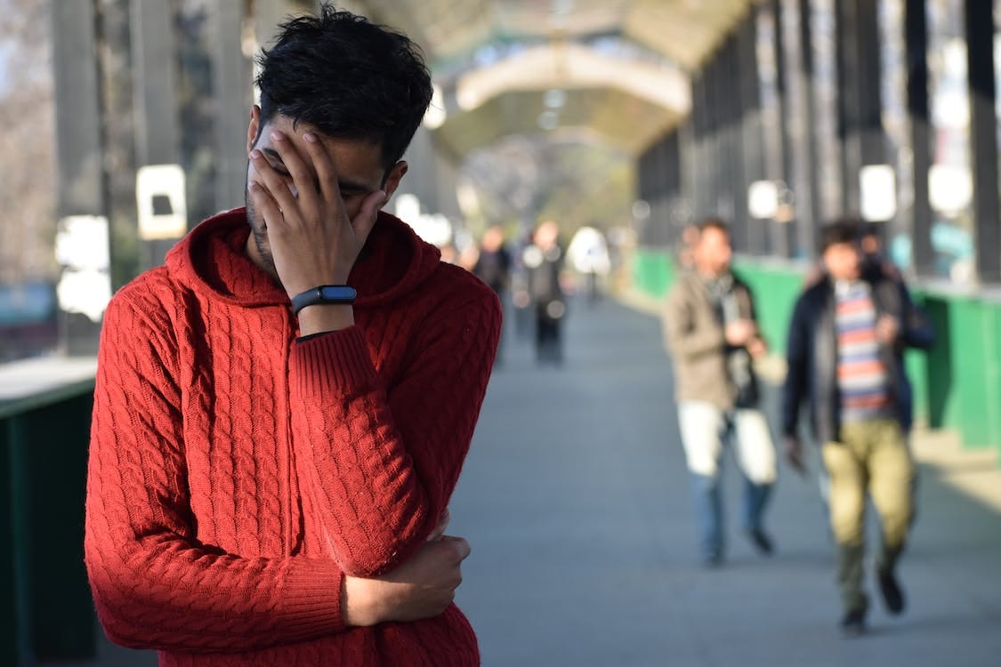 Free A Man Wearing Knitted Hoodie Jacket Standing on the Street while Doing Face Palm Stock Photo
