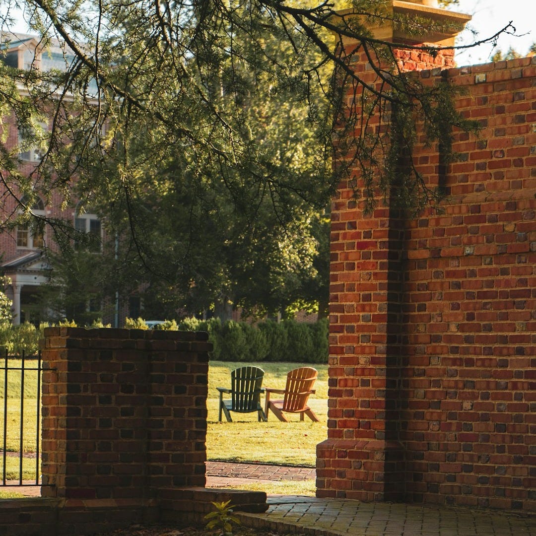 a brick walkway with a chair in the background