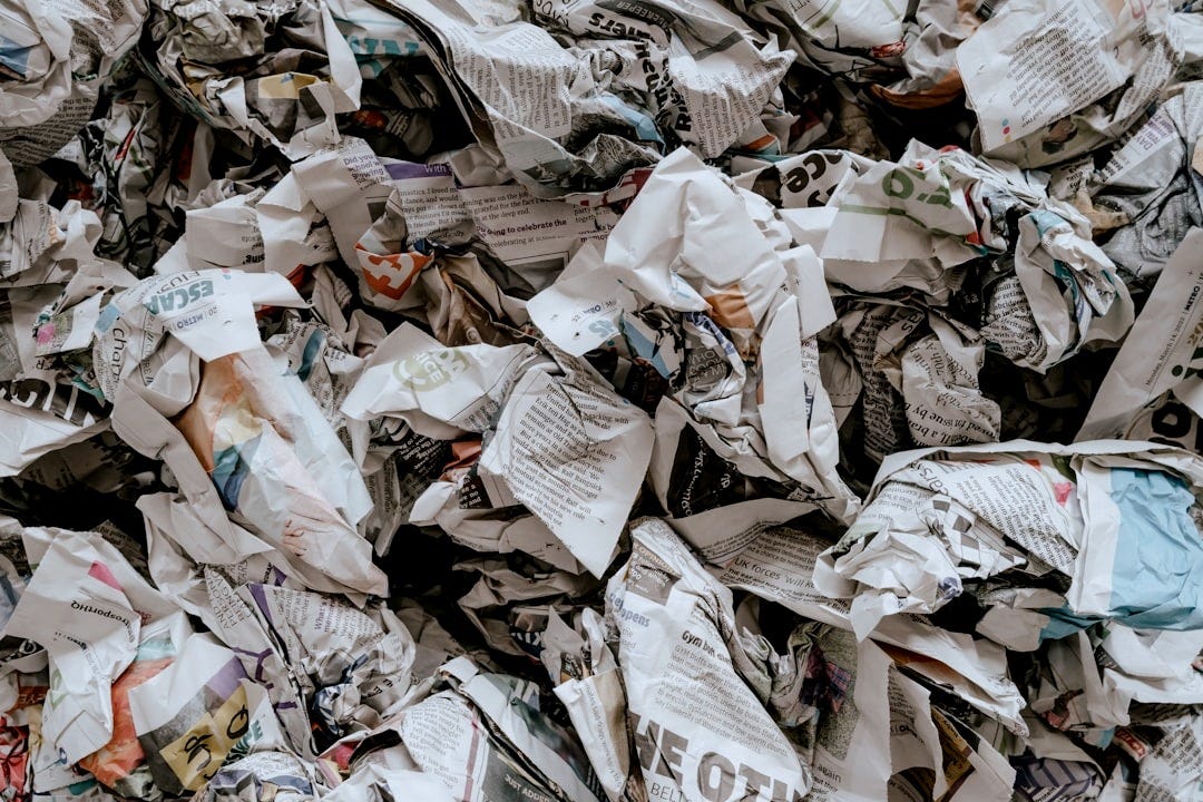 a pile of newspaper with a lot of paper on top of it a pile of newspaper with a lot of paper on top of it
