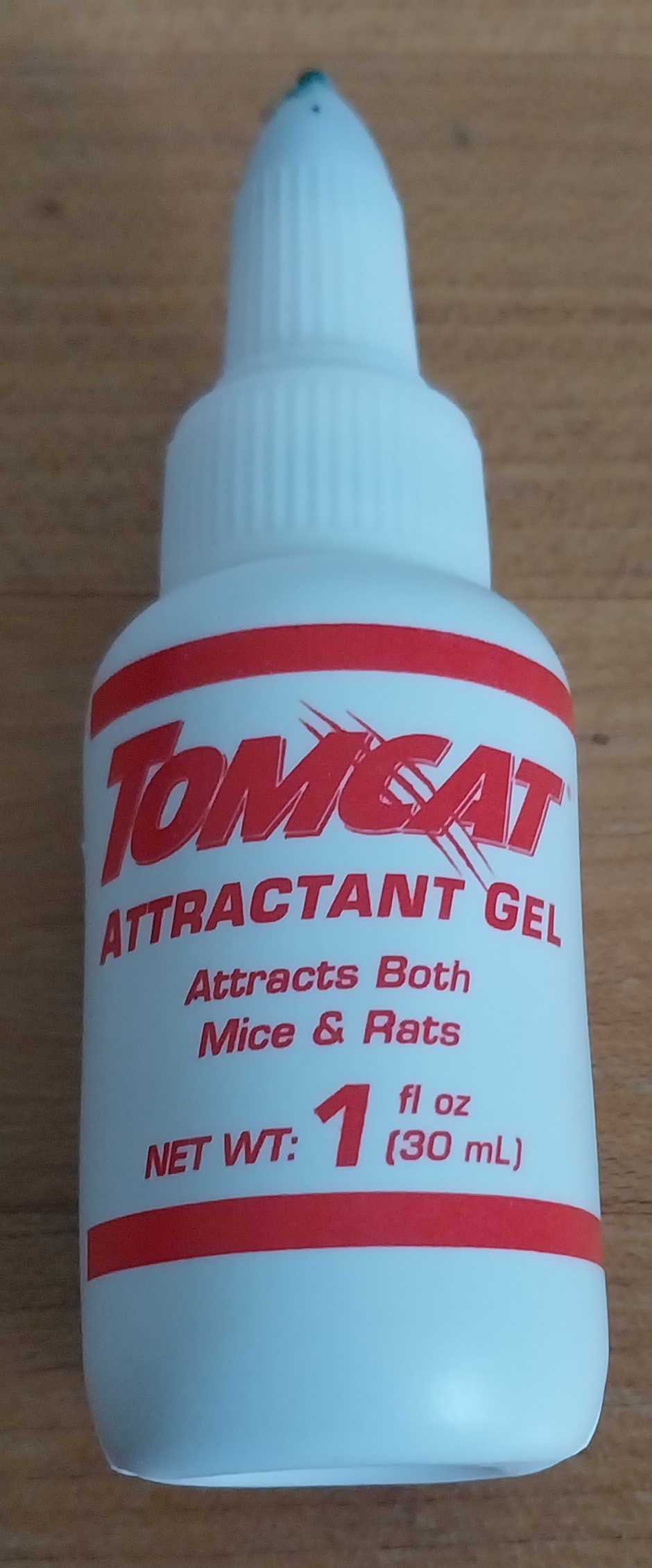 A white one fluid ounce (30 mL) bottle of "TOMCAT ATTRACTANT GEL" with red print, which claims it "Attracts Both Mice & Rats."