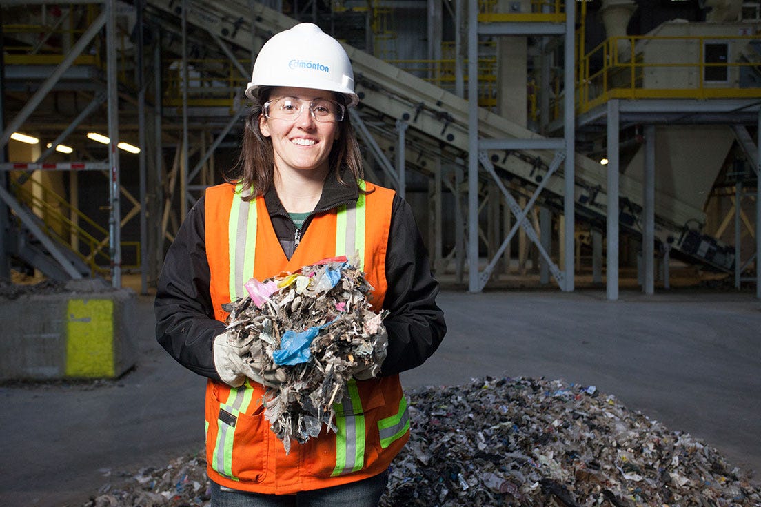 City promotional photograph showing an employee holding shredded refuse-derived fuel inside a processing facility City promotional photograph showing an employee holding shredded refuse-derived fuel inside a processing facility