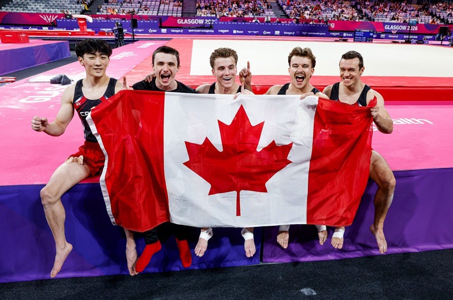 Saskatoon's Jordan Carroll (second from left) celebrating with his Canadian teammates after winning gold in the men's team gymnastics event at the 2026 Commonwealth Games on Friday.