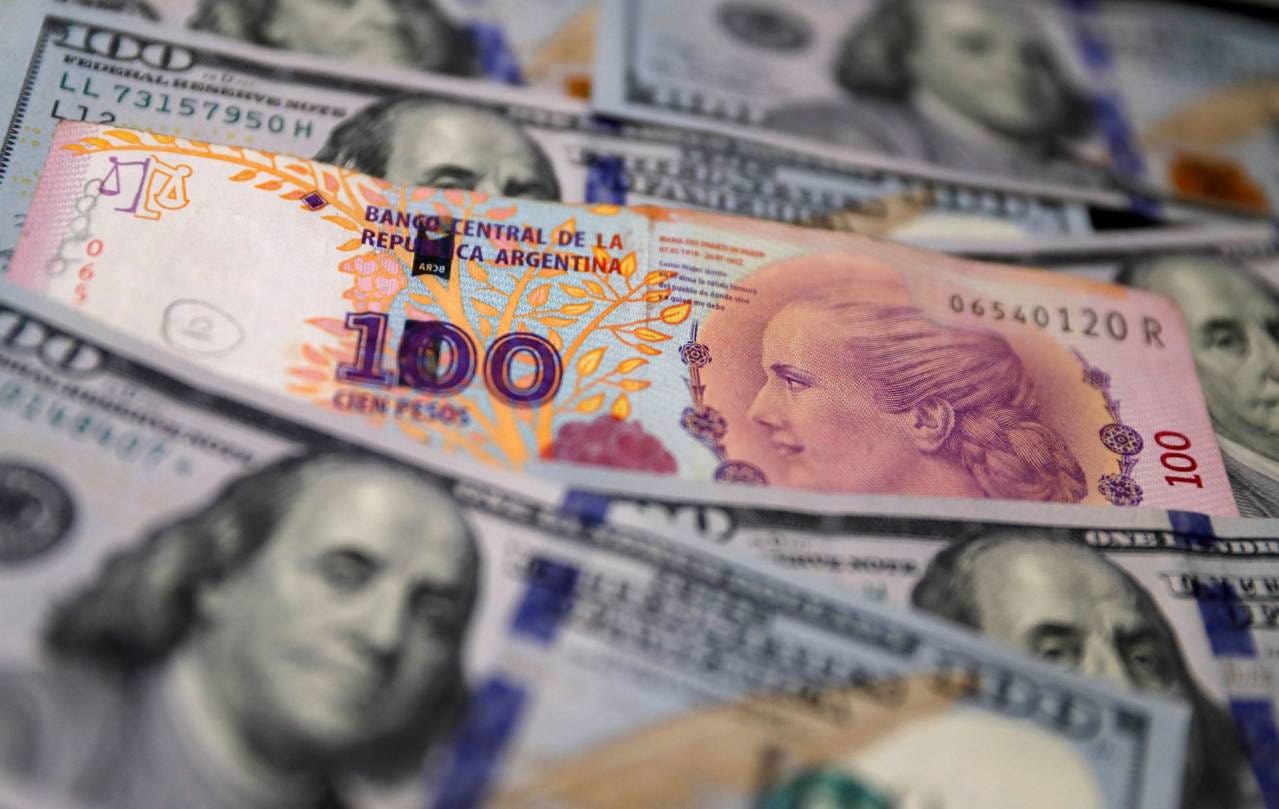 Cédulas de 100 pesos e 100 dólares - 17/10/2022 (Foto: REUTERS/Ilustração/Agustin Marcarian)