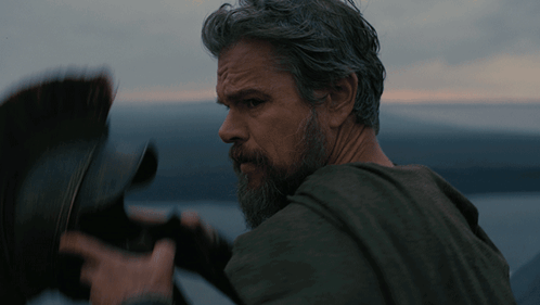 a man with gray hair and a beard looks at something a man with gray hair and a beard looks at something