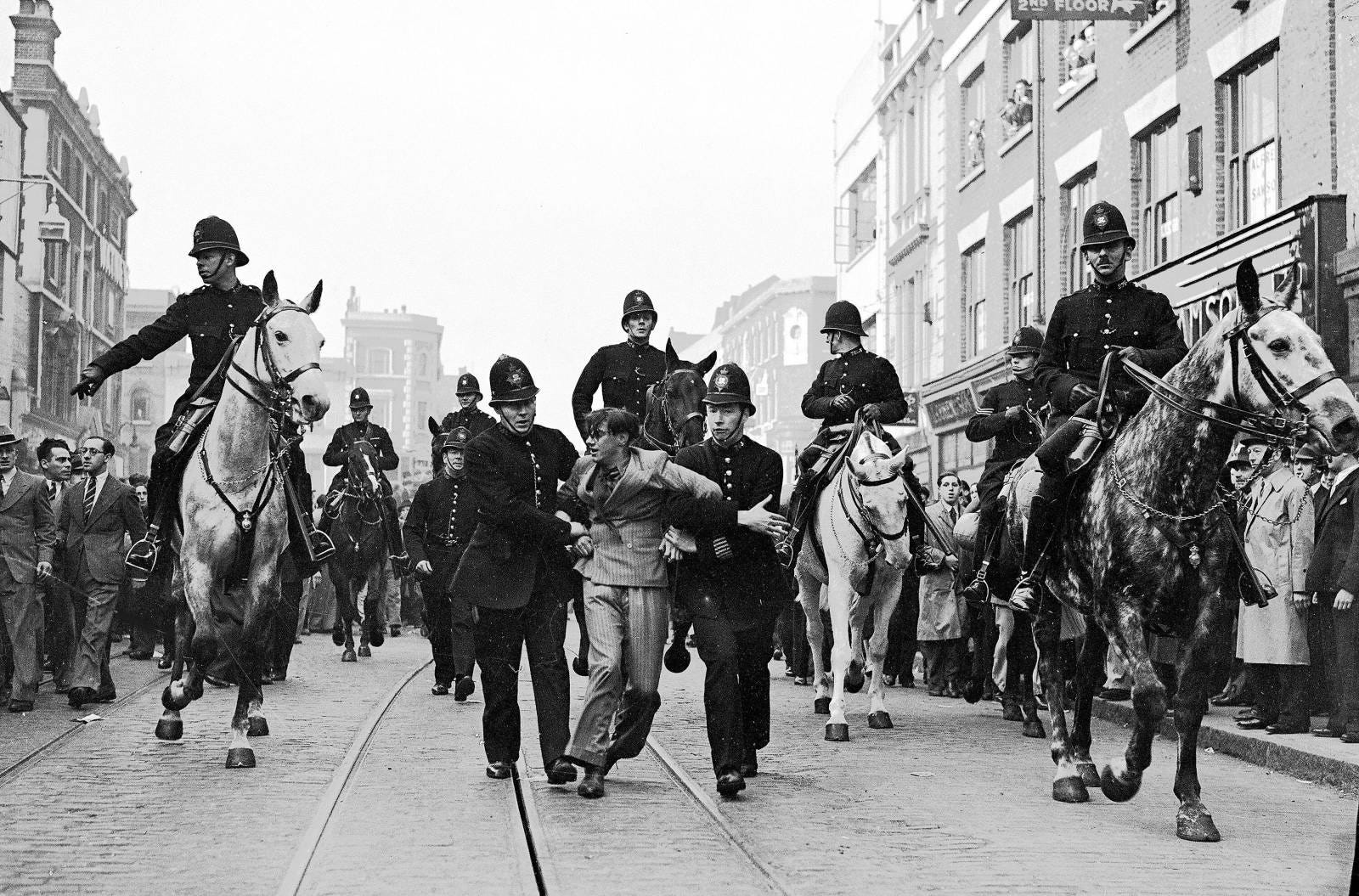 Eddie Worth, An anti-fascist demonstrator is taken away under arrest after a mounted baton charge during the Battle of Cable Street, London, 4 October 1936 Eddie Worth, An anti-fascist demonstrator is taken away under arrest after a mounted baton charge during the Battle of Cable Street, London, 4 October 1936