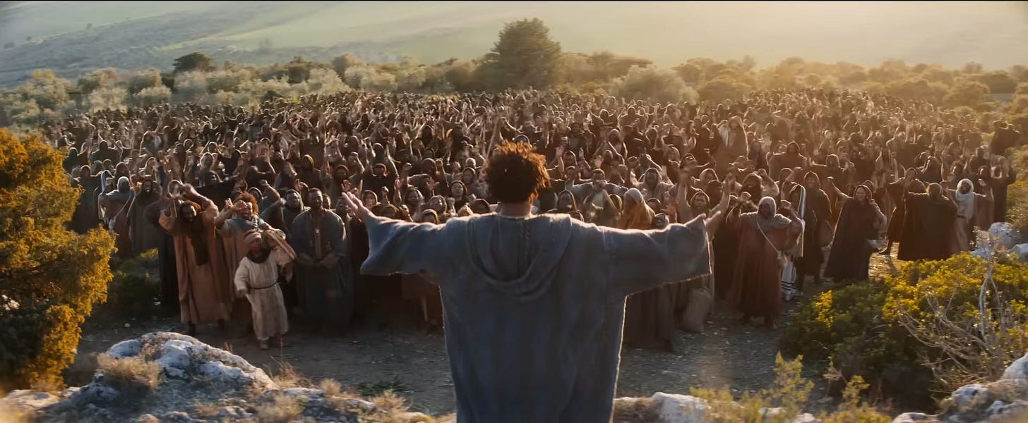 Clarence holds out his arms as he preaches to a crowd