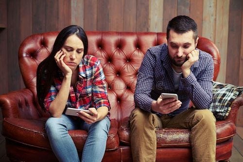 Bored young couple sitting on couch and looking at their phones. Couple phones stock images, royalty-free photos and pictures