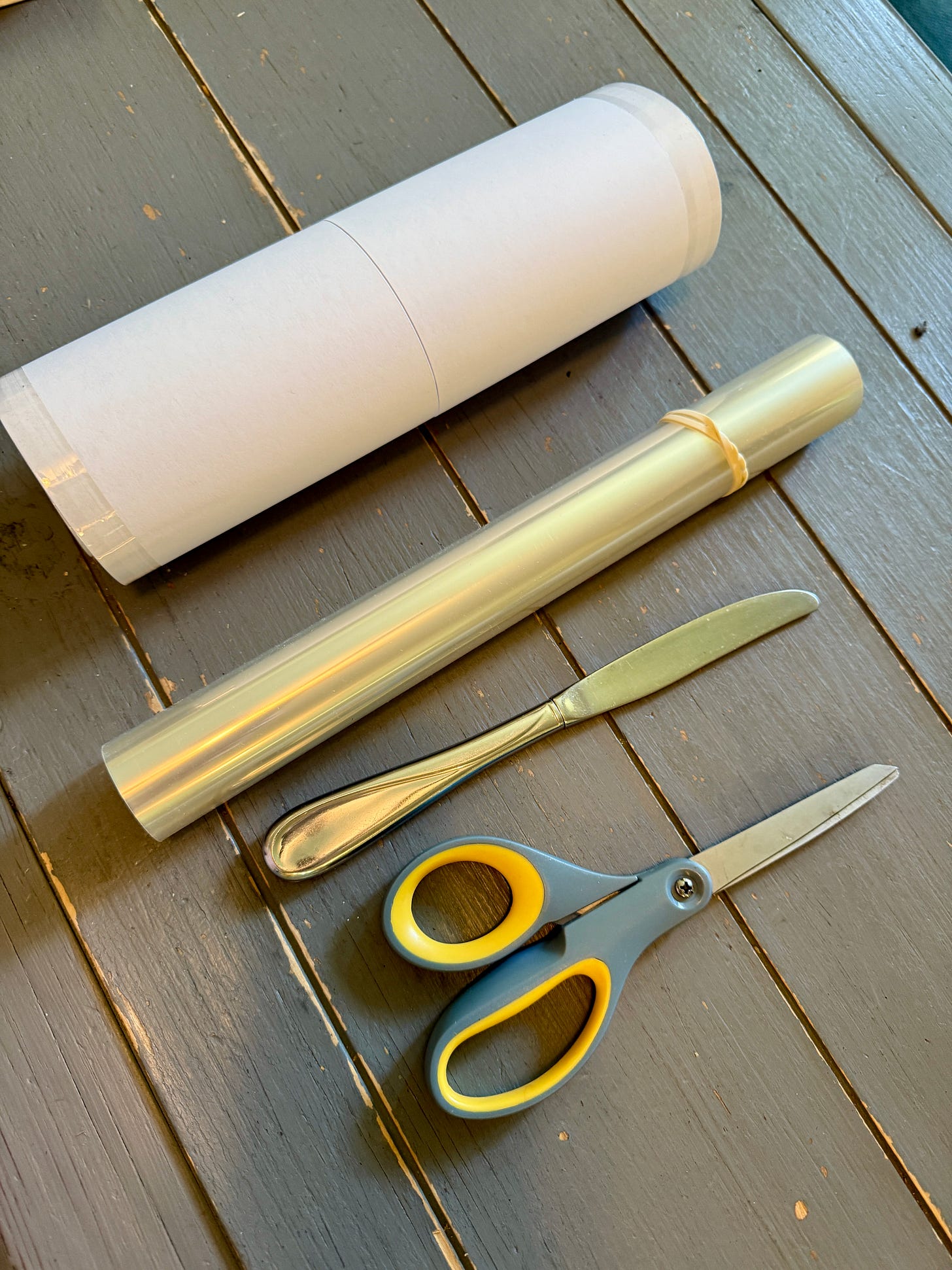 Here are two different types of mylar covers: one with the paper split in the middle and one without paper. I also use the rounded handle of a table knife to help crease the mylar, and a pair of scissors to cut my cover off the roll. 
