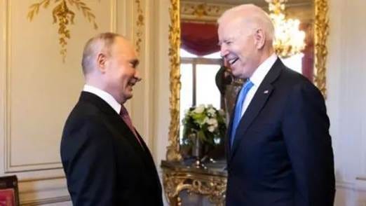 Getty Images Putin and Biden laugh together in a luxuriously decorated room