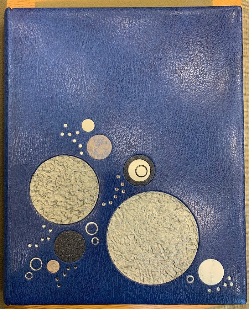 Upper board of Conway's binding, full blue morocco leather, silver tooling, black morocco and blue and silver calf circular insets